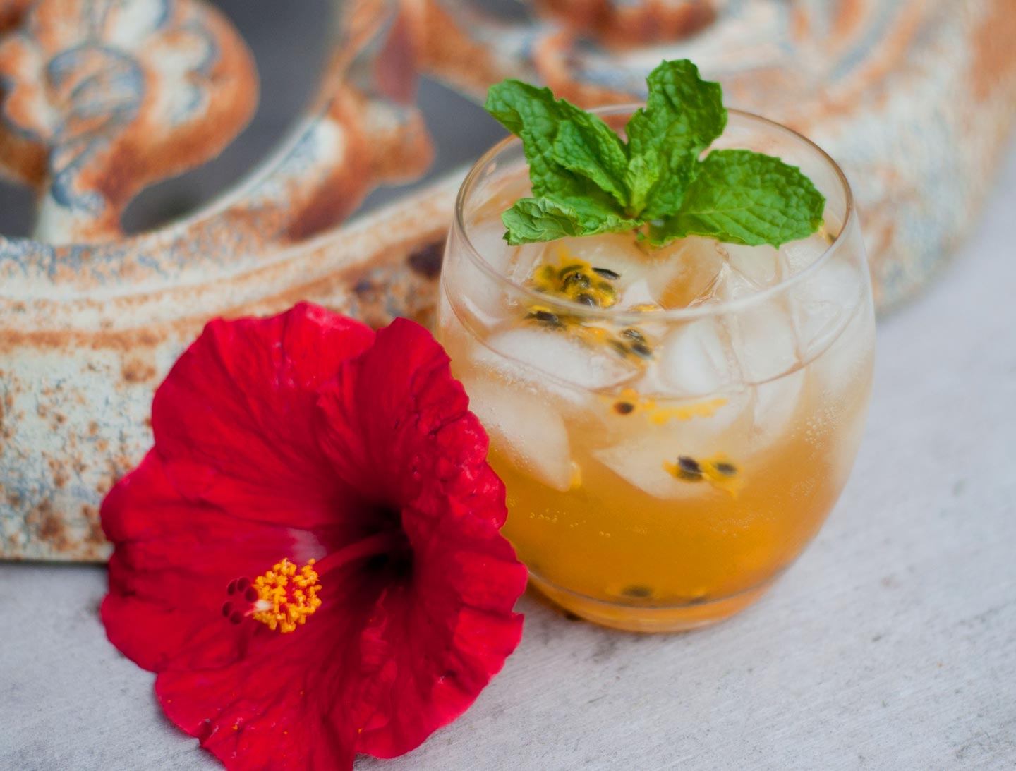 Mauka Mule Cocktail Recipe with a red hibiscus flower next to the glass and a sprig of mint as a garnish