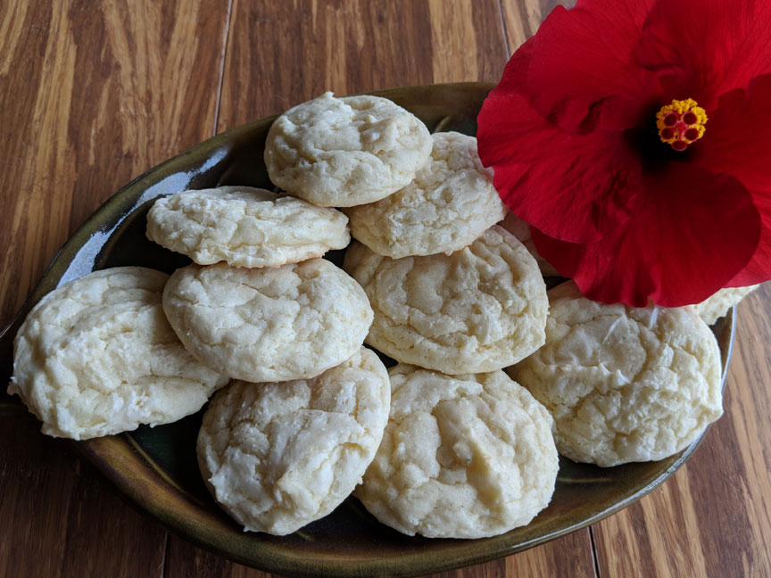 Passion Fruit Sugar Cookies with a red hibiscus flower on the plate