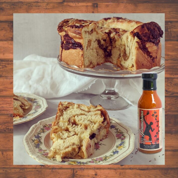 Onion Soup Bread Recipe on a plater with a bottle of Passion Fruit Chili Pepper Sauce