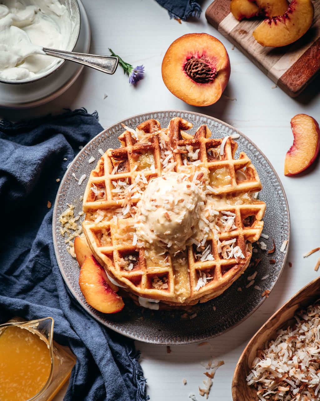 Passion Fruit and Peach Waffles on a table with a blue napkin