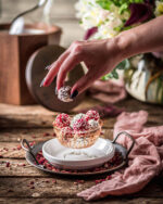 A female hand taking a Passion Fruit Milk Chocolate Hand Rolled Truffle out of a bowl of red and white truffles